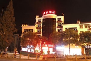 Un hotel con una entrada destacada, varios pisos y una fachada bien iluminada.