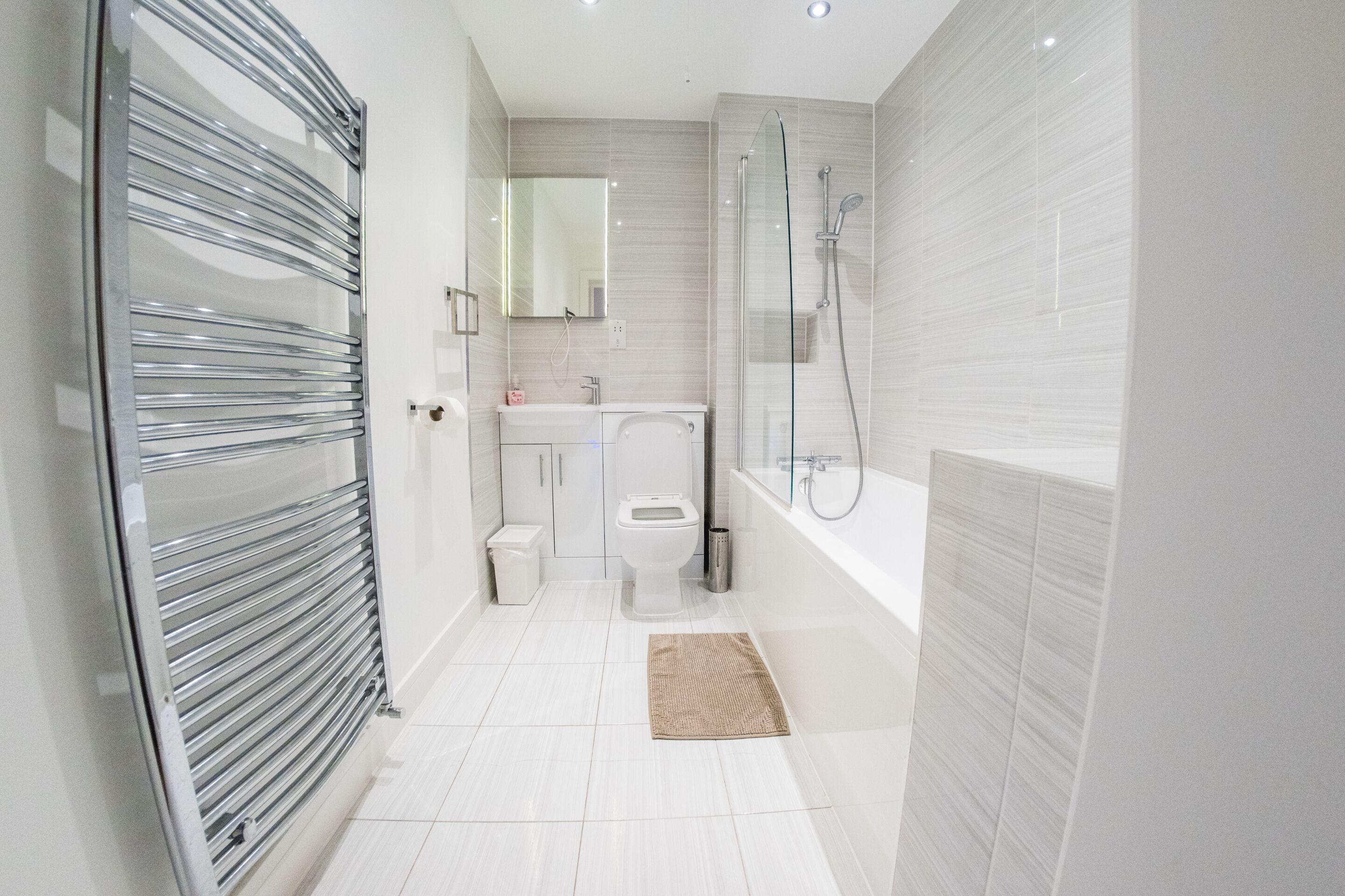 A modern bathroom with a toilet, sink, and shower.