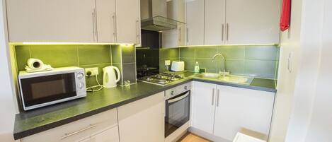 A modern kitchen with a microwave, stove, oven, and sink.