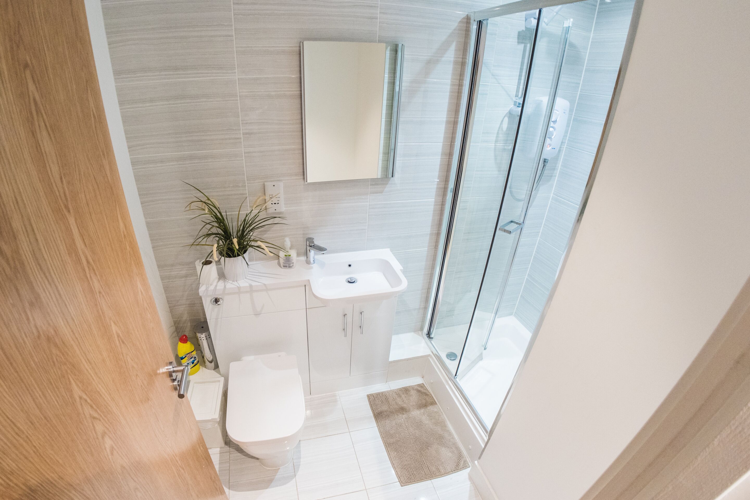 A modern bathroom with a toilet, sink, and shower area.