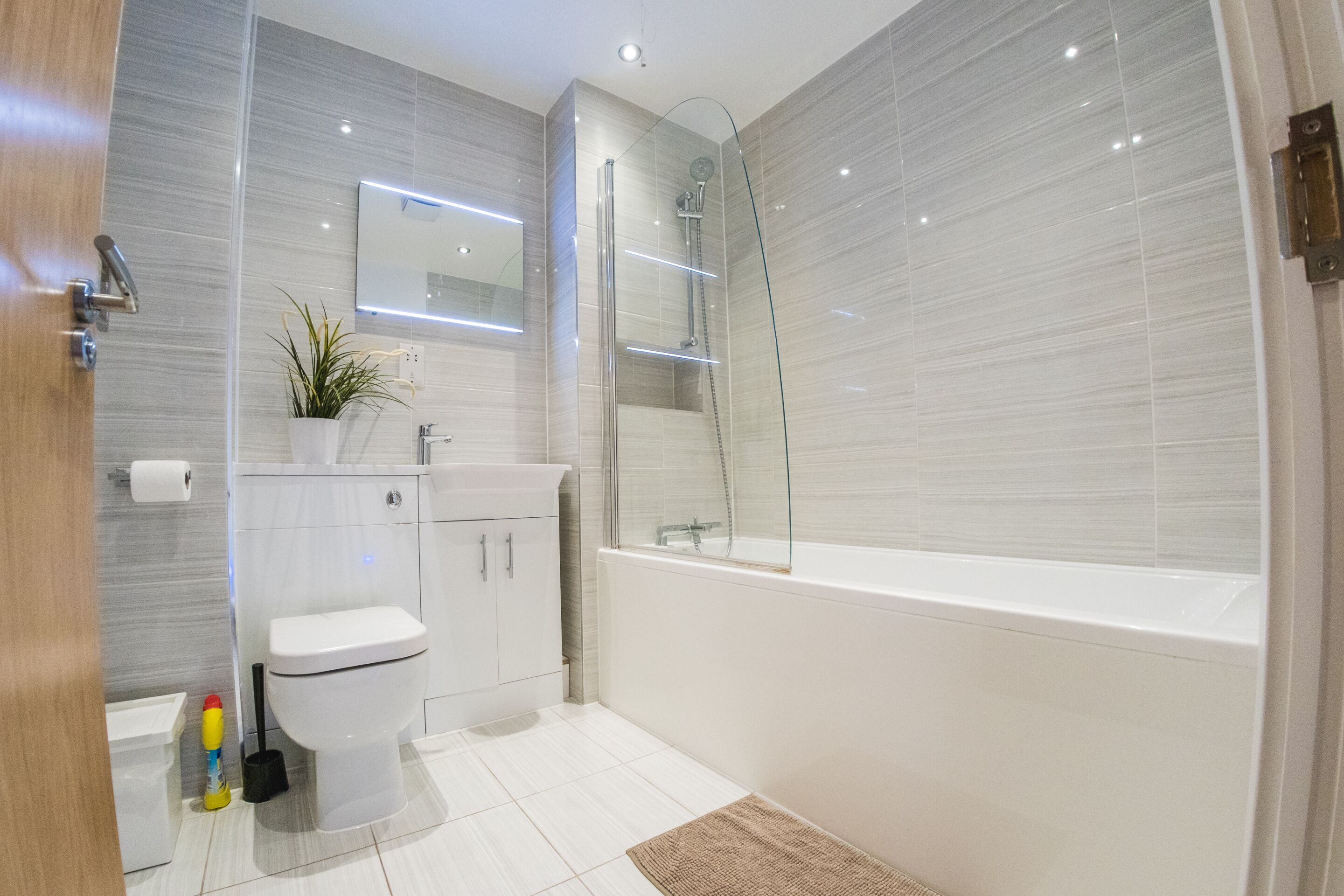 Un baño moderno con inodoro, lavamanos y ducha.