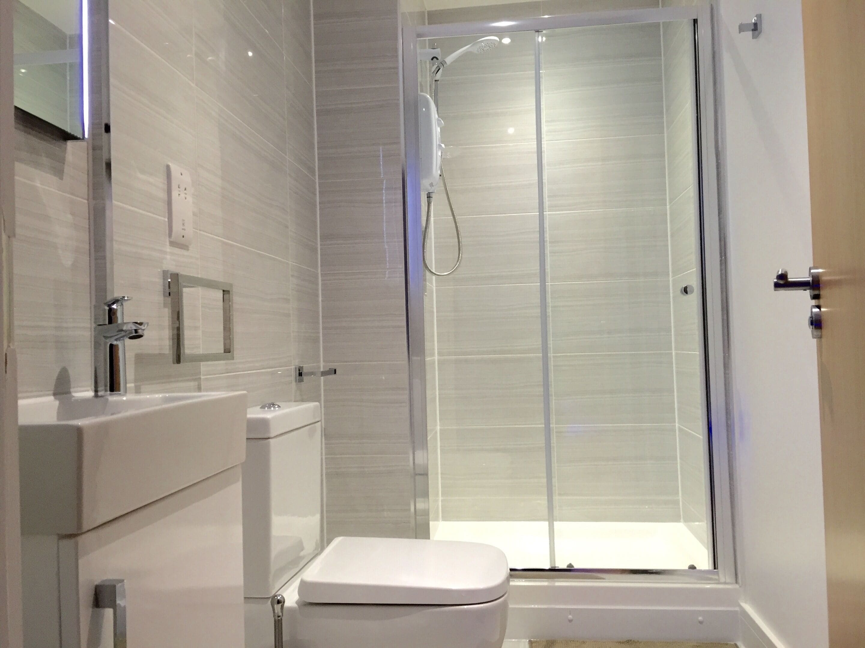 Une salle de bain moderne avec une douche à parois de verre, des toilettes et un lavabo.