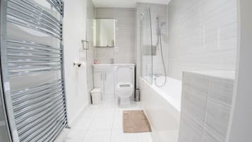 Un baño moderno con cabina de ducha de vidrio, inodoro y lavamanos.