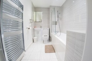 A modern bathroom with a glass shower enclosure, a toilet, and a sink. - Ilford Tower Apartments (Ilford)