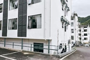 Un immeuble à plusieurs étages, doté d’une façade blanche, de grandes fenêtres et d’un toit plat.