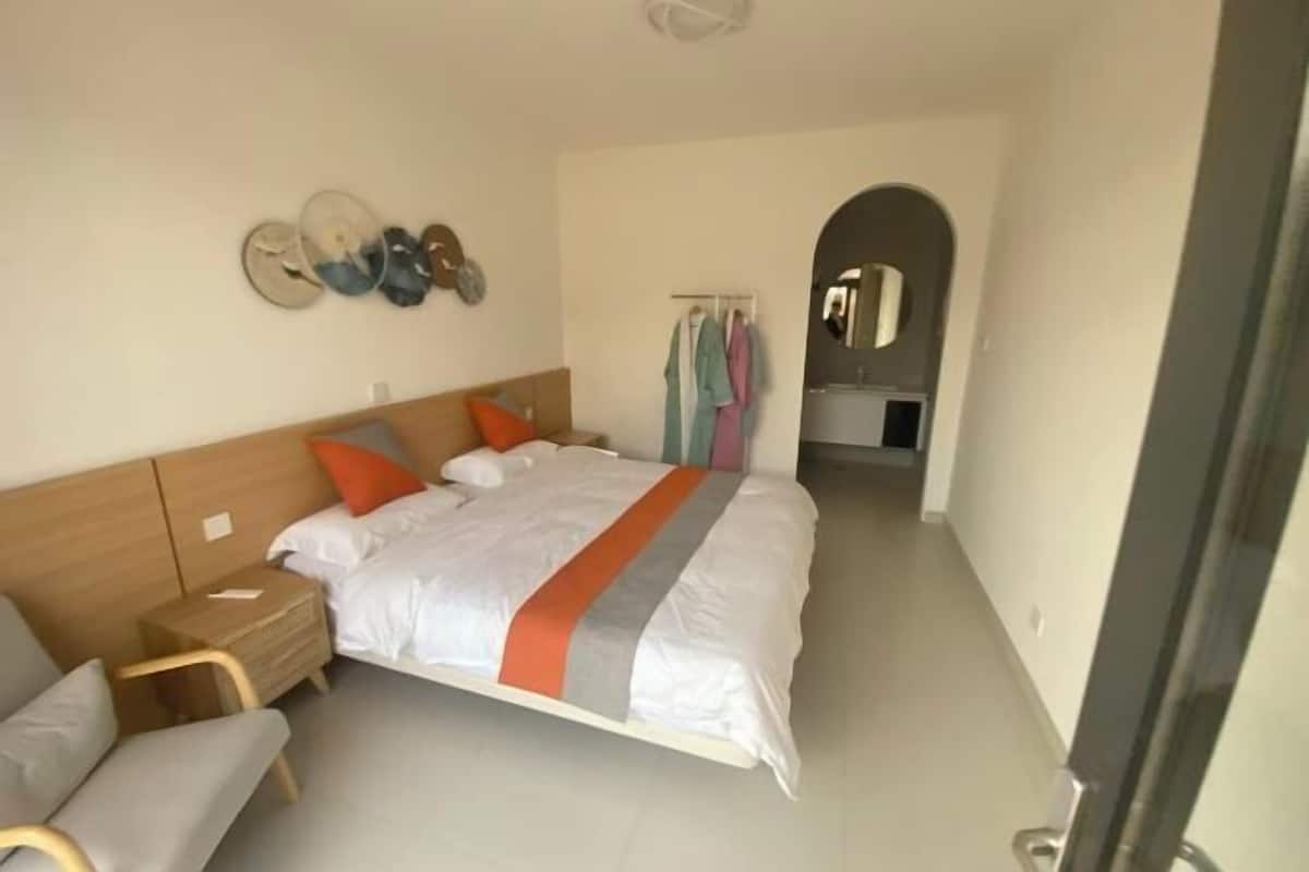 Quarto com cama, mesa de cabeceira e uma cadeira.