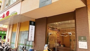 Un hotel con un letrero que dice 'Maxhill Inn' y otro anuncio para 'One Heart Clinic'.