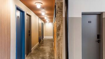 A hallway with doors numbered 101 and 108, a textured wall, and a ceiling with recessed lighting.
