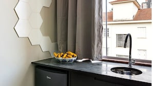 A kitchen with a window, a sink, and a bowl of bananas on the counter. - Zest Teodoro (São Paulo)