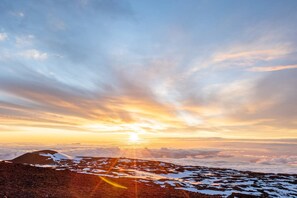 Berglandschaft mit Sonnenuntergang und Schneeflächen.