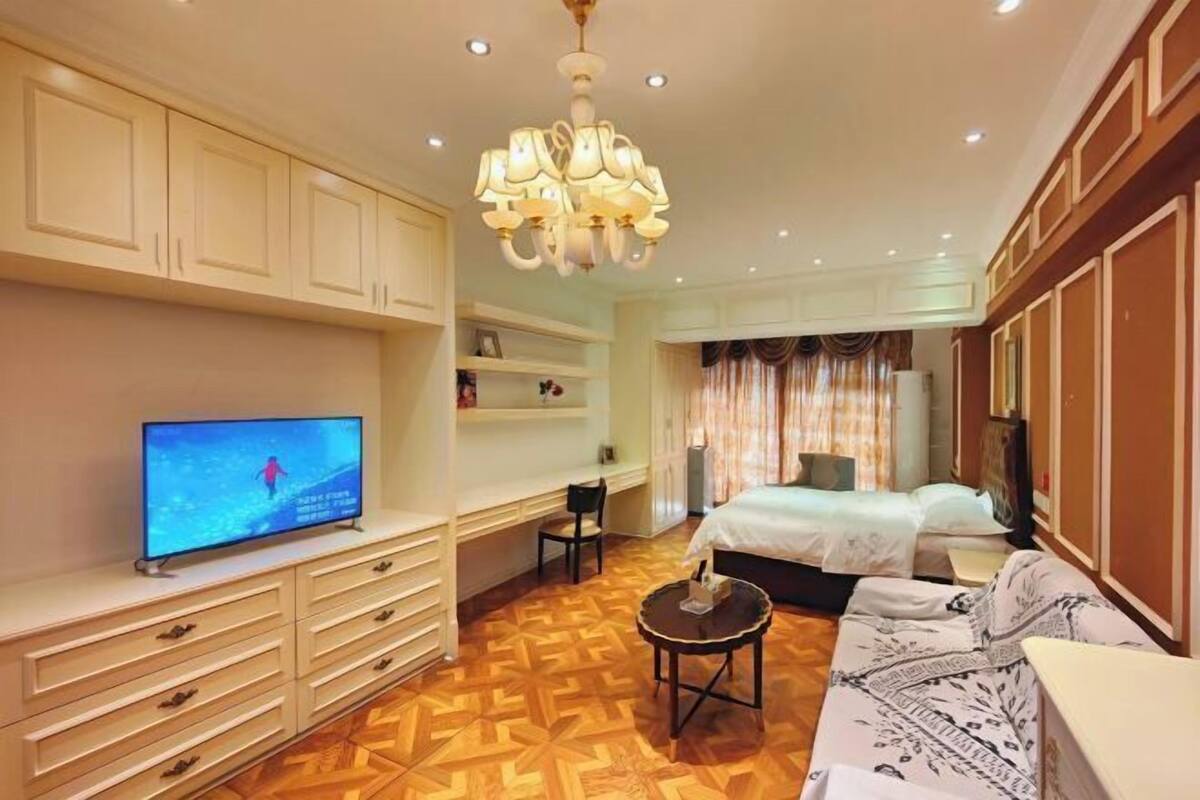 Une chambre d’hôtel équipée d’une télévision, d’un bureau, d’un lit et d’un canapé.