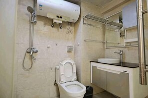 A bathroom with a toilet, sink, shower, and a towel rack. - Shuangshu Apartment Hotel (Changsha Chuangshiji Plaza) (Changsha)
