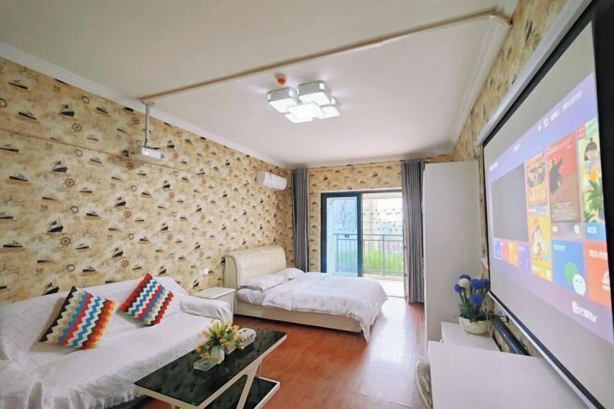 Une chambre d’hôtel avec un lit, un canapé, une télévision et un balcon.