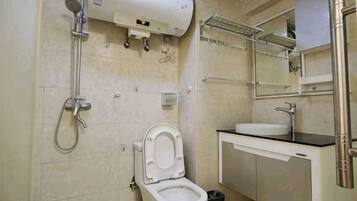 A bathroom with a toilet, sink, and shower.