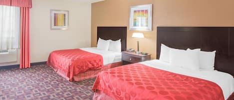 A hotel room with two beds, a nightstand, a lamp, and a window with curtains.