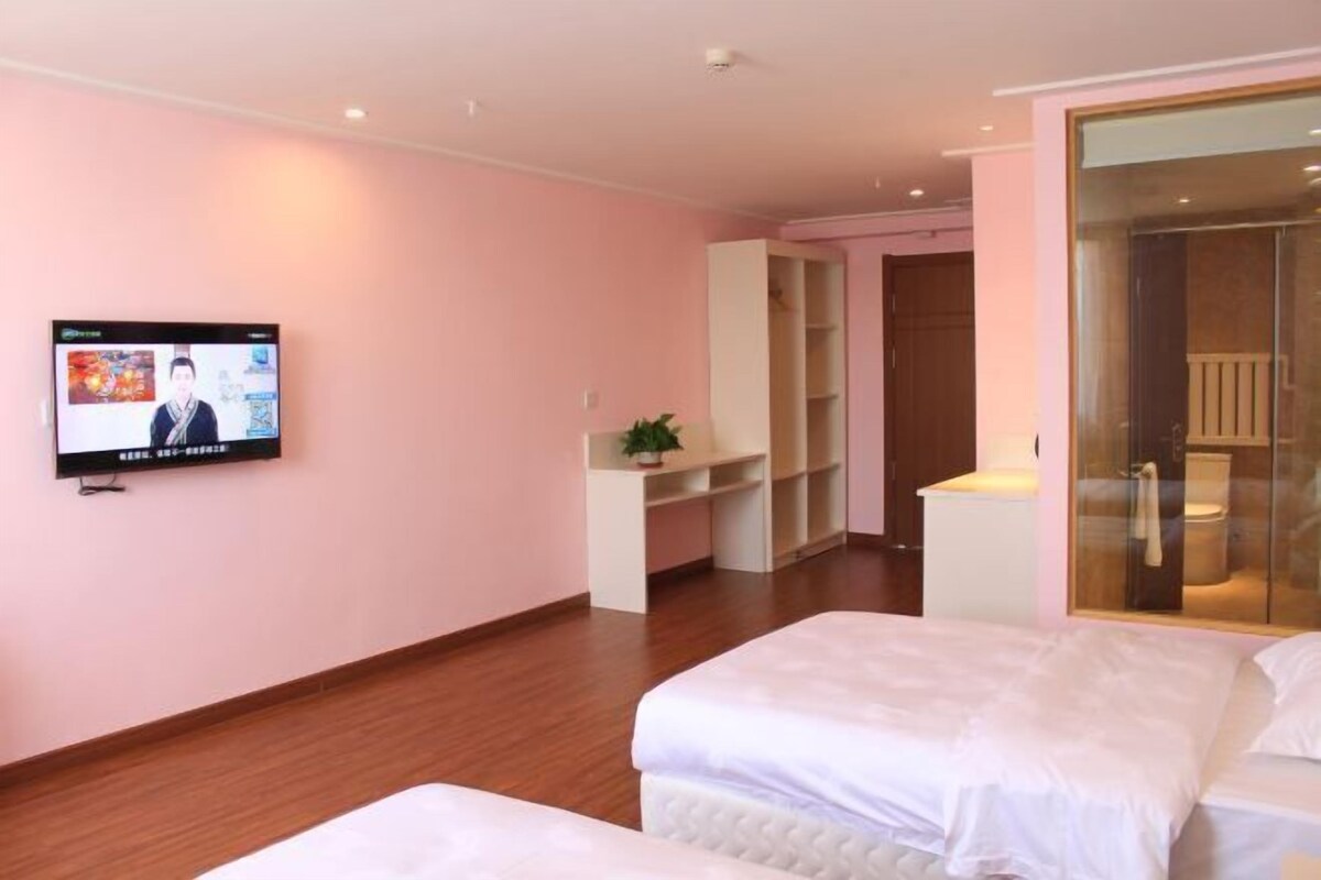 Una habitación de hotel con cama, televisión, escritorio y armario.