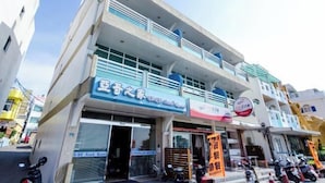 A multi-story building with a ground-floor shop and upper-floor residential units. - Yake Hostel (Pingtung)
