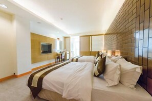 A hotel room with two beds, a TV, a desk, and a brick-patterned wall. - Yake Hostel (Pingtung)