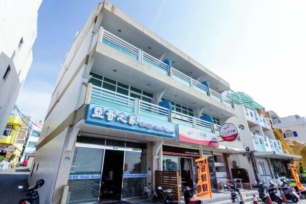 Un edificio de dos pisos con una tienda en la planta baja y viviendas en el nivel superior.