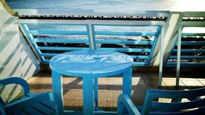 A blue table and chairs on a balcony with a view of the ocean. - Yake Hostel (Pingtung)