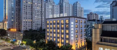 A multi-story hotel with a modern facade, located in an urban setting with high-rise buildings in the background.
