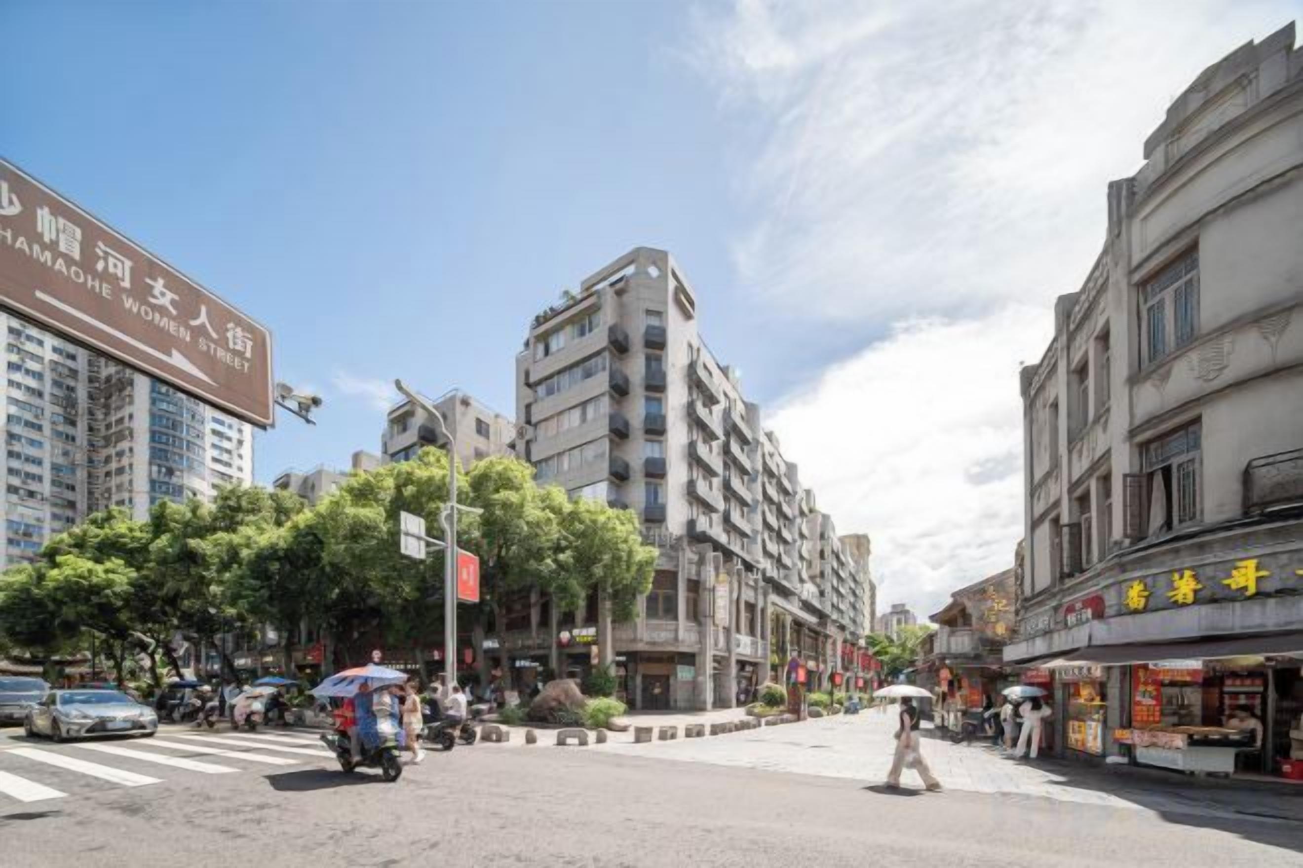 A street view with multi-story buildings, a crosswalk, and pedestrians.