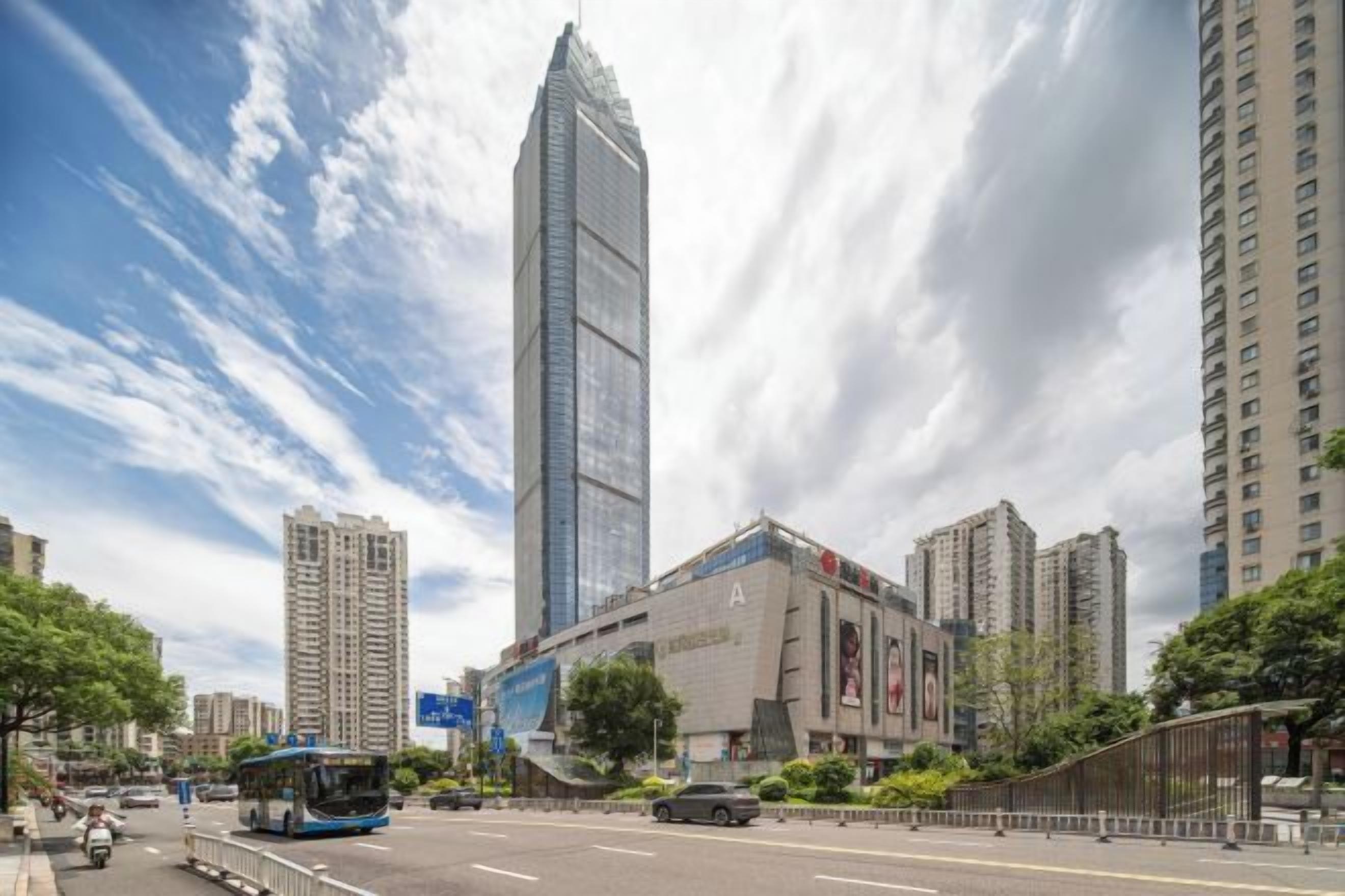 Ruas da cidade com edifícios altos, um ônibus e uma passarela para pedestres.