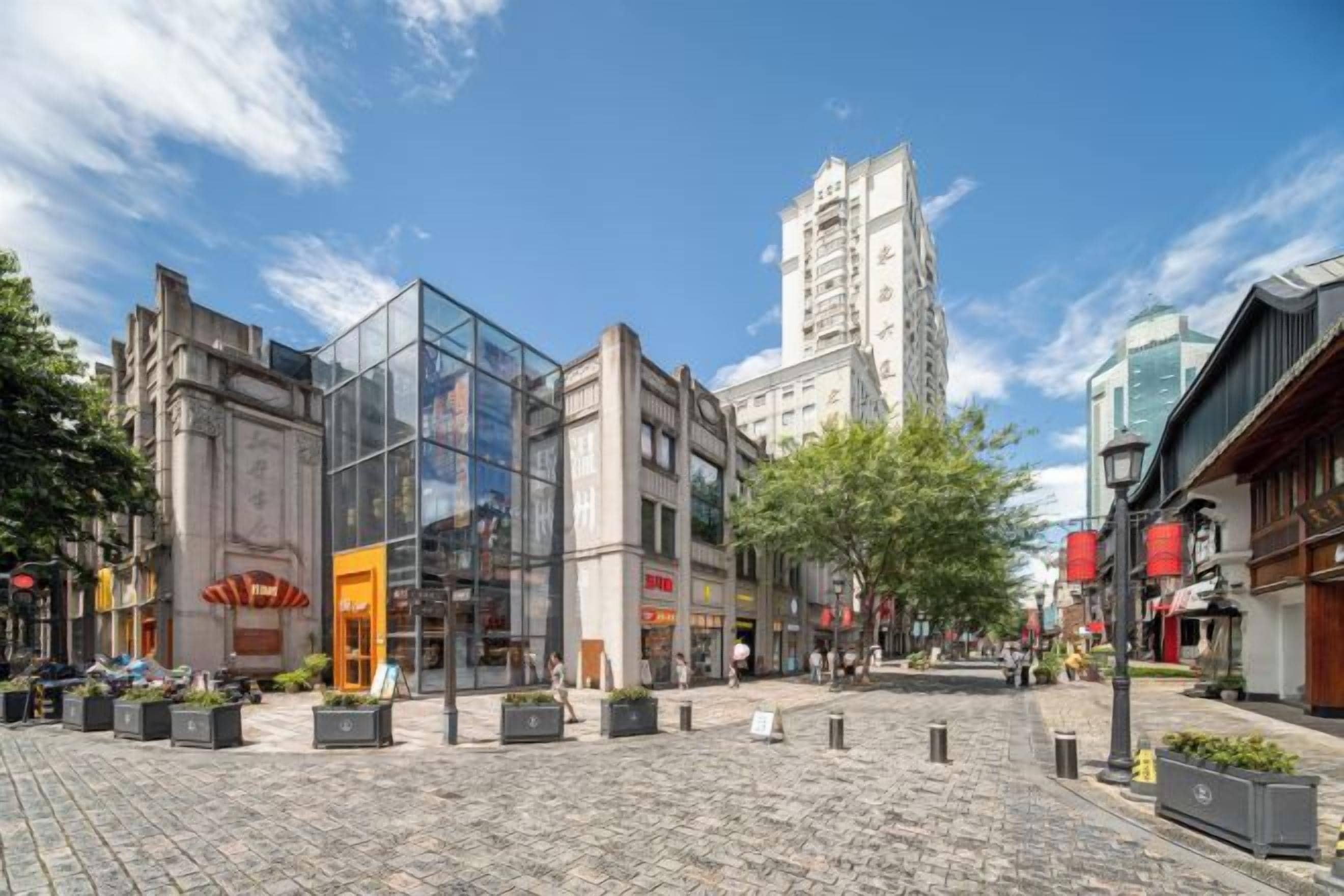 Ein Kopfsteinpflasterplatz mit modernen und traditionellen Gebäuden, einem klaren Himmel und einem offenen zentralen Bereich.