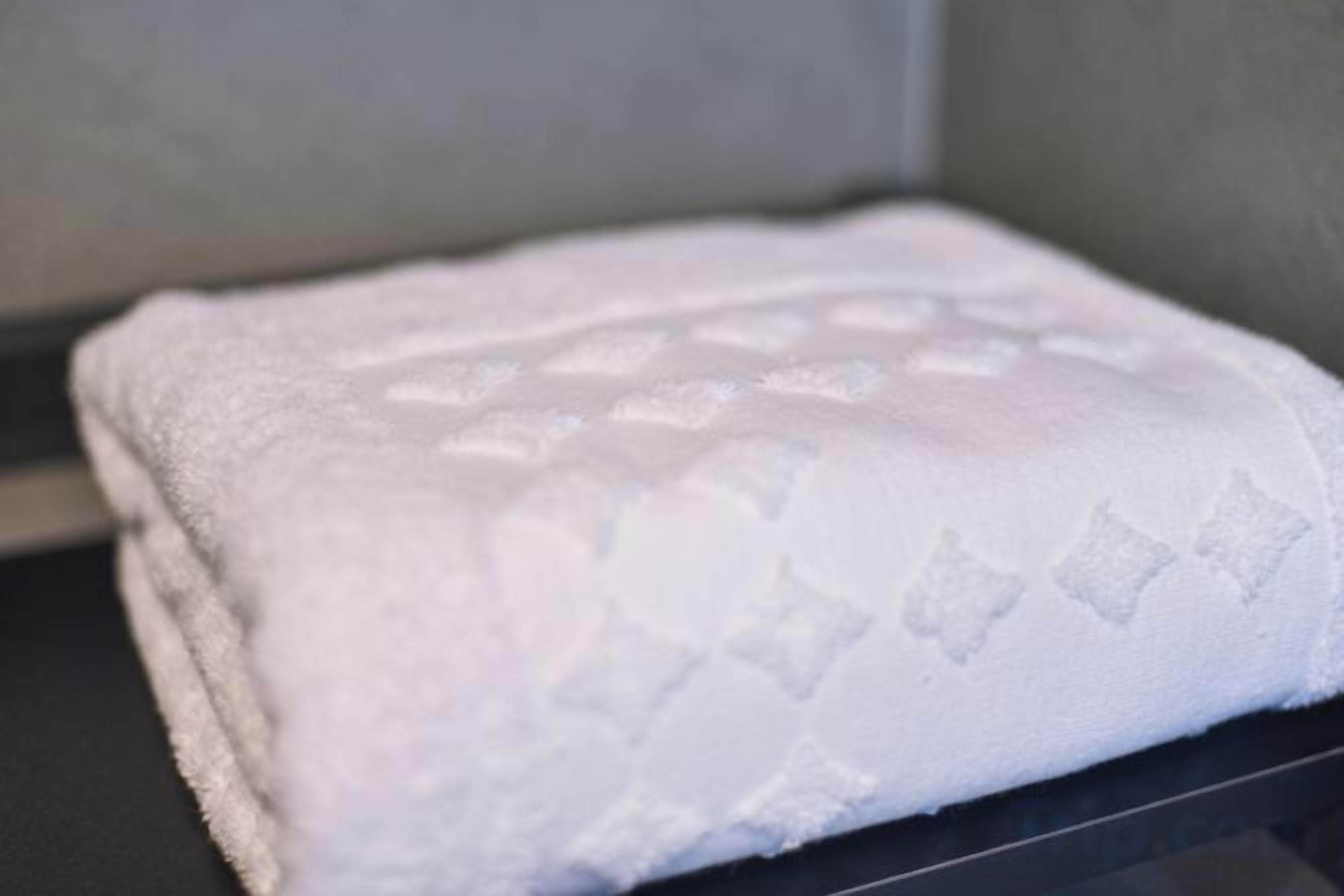 A white towel with a diamond pattern on a black surface.