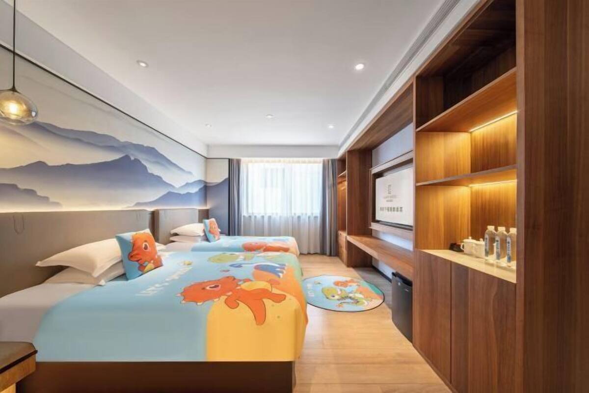 A hotel room with a bed, bedside tables, a wall-mounted TV, and a wooden shelving unit.