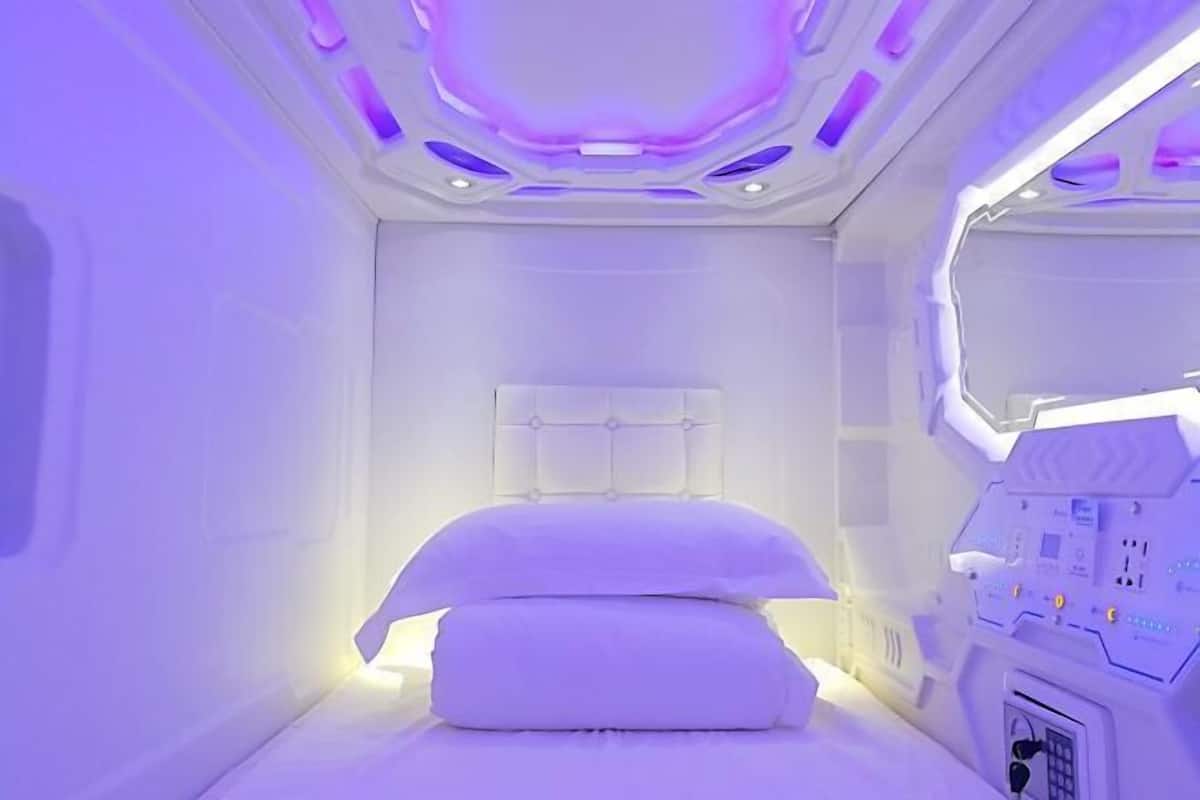 A room with a bed, a control panel, and a window.