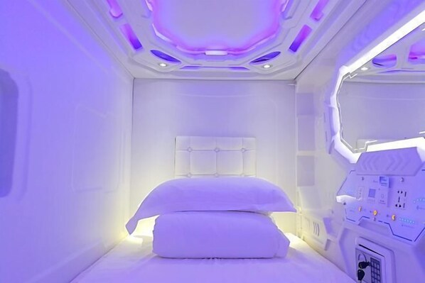 Una habitación con una cama, un panel de control y un ventanal.