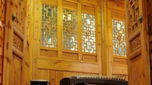 A wooden interior with traditional lattice windows and a black object on the floor.