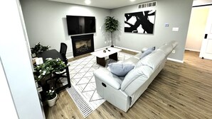 Una sala de estar moderna con sofá, mesa de centro y chimenea.