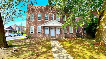 A two-story brick building with a central entrance and a small porch.