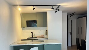 Une cuisine moderne dotée d’un îlot central, de tabourets de bar et d’un coin repas avec des chaises.
