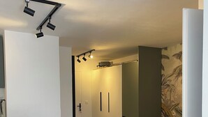 Une cuisine moderne avec un plan de travail blanc et un coin repas comprenant deux chaises noires et une table ronde.