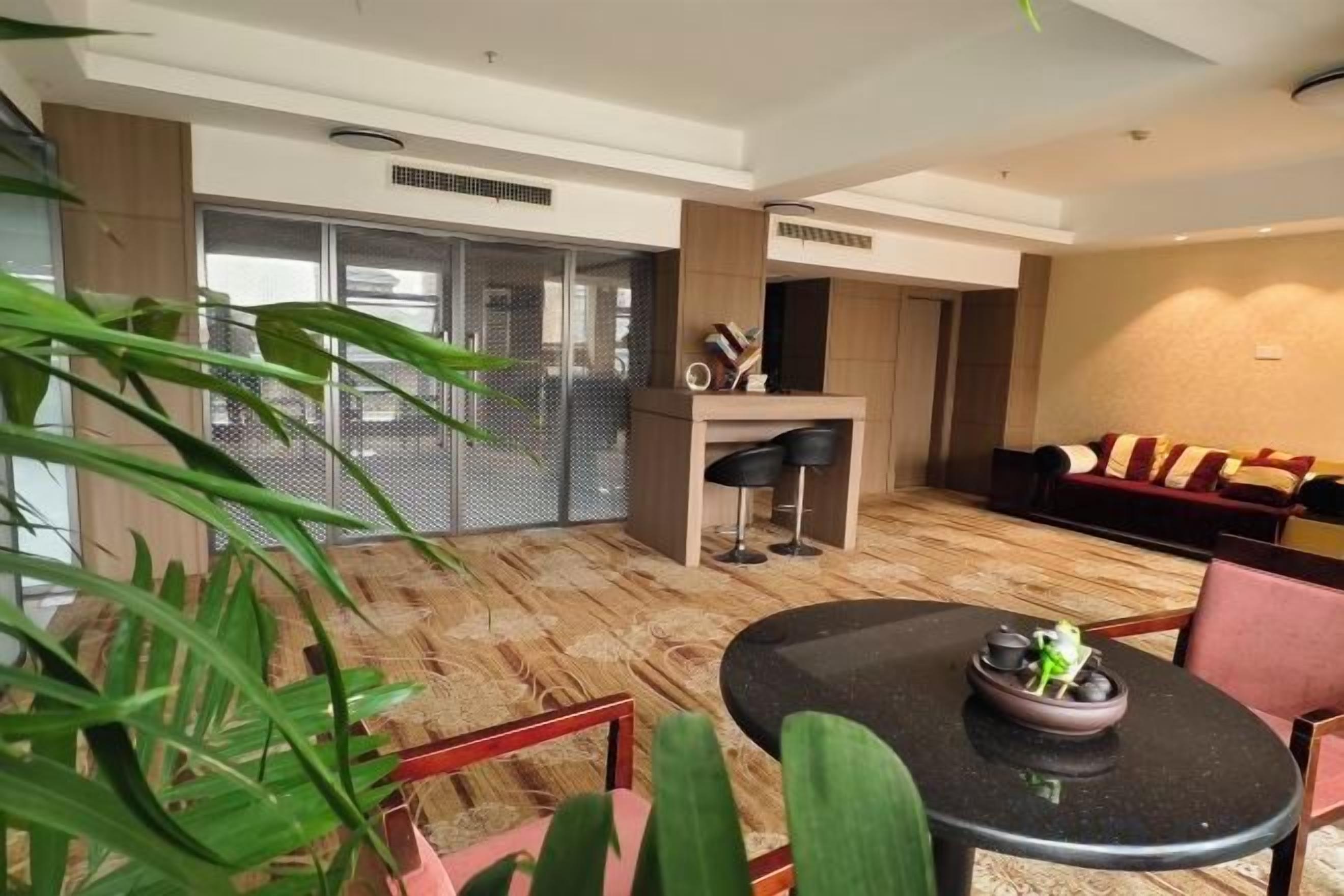 Habitación de hotel moderna con zona de comedor, un conjunto de sofás y un amplio ventanal con vistas.