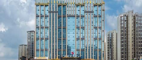 A high-rise building with multiple floors, large windows, and a central entrance.