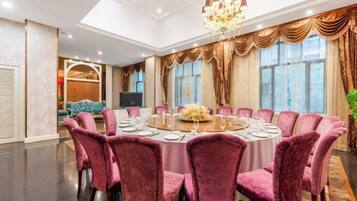 Un comedor formal con una mesa redonda, varias sillas y una araña.
