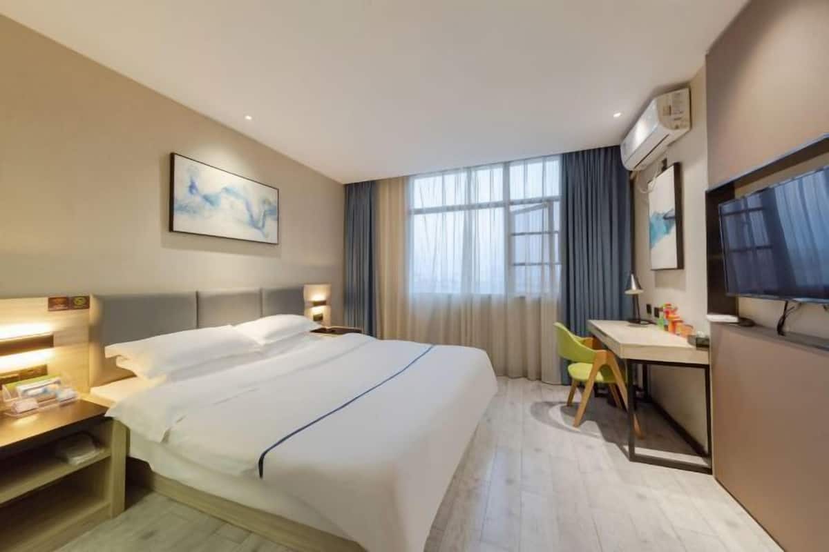 Une chambre d’hôtel équipée d’un lit, d’un bureau, d’une chaise et d’un téléviseur.