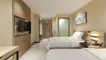A hotel room with two beds, a TV mounted on the wall, a painting, and a bedside table with a lamp.