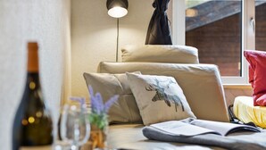 A cozy room with a sofa, pillows, a bottle, glasses, and a notebook. - Haus Bodmen B Apartment B 43 by Interhome (Zermatt)