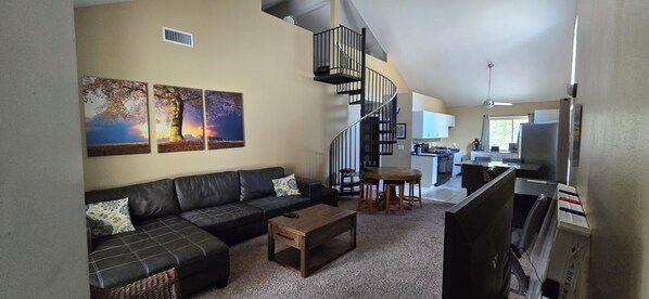 A living room with a sofa, coffee table, and artwork on the wall.