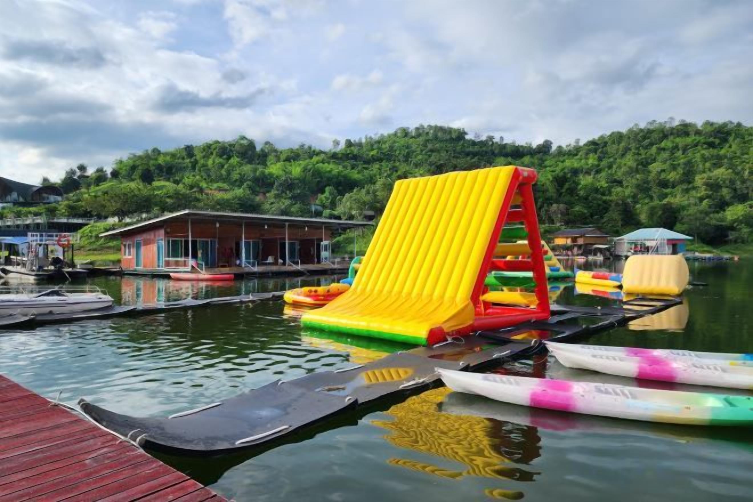 A water park with inflatable slides and rafts on a dock.