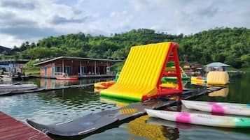 A water park with inflatable slides and rafts on a dock.