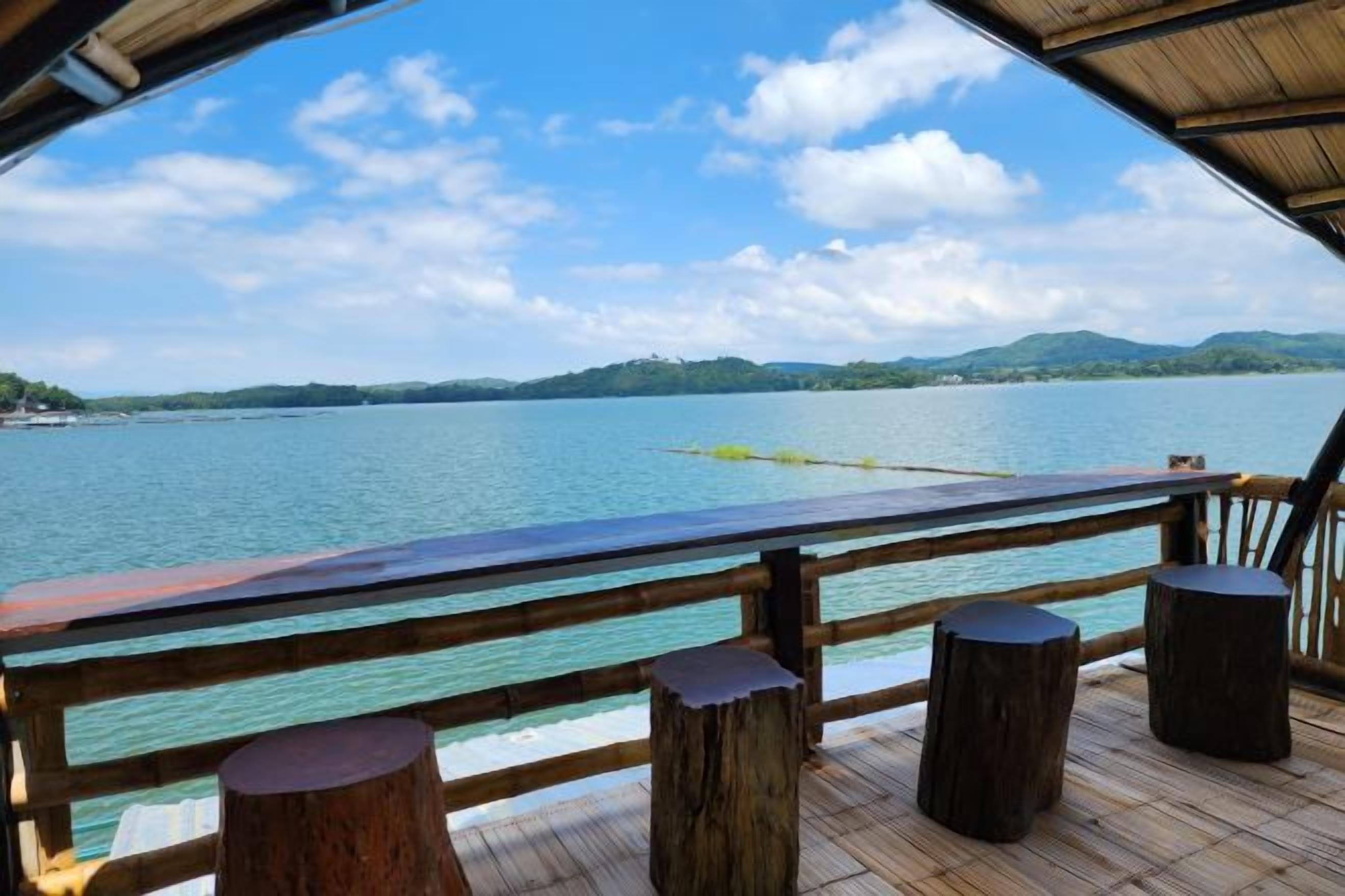 A wooden deck with a view of a lake and distant mountains.