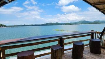 A wooden deck with a view of a lake and distant mountains.