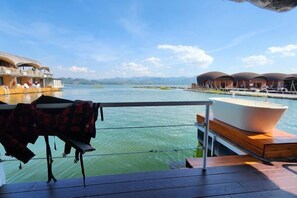 A deck with a boat and a row of overwater bungalows.