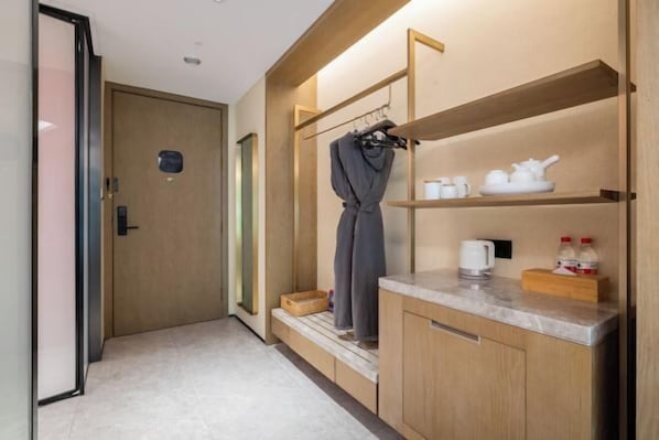 A compact hotel room with a wooden wardrobe, a small kitchenette, and a shower area. - Nanjing Bojin Blossom Hill · Pipa Mountain Lodge (Sun Yat-sen's Mausoleum) (Nanjing)